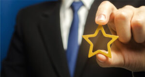 a man holds a gold star, a symbol of his success and excellence