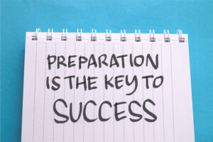 Lined notebook with the words ‘Preparation is the key to success’ written on the page.