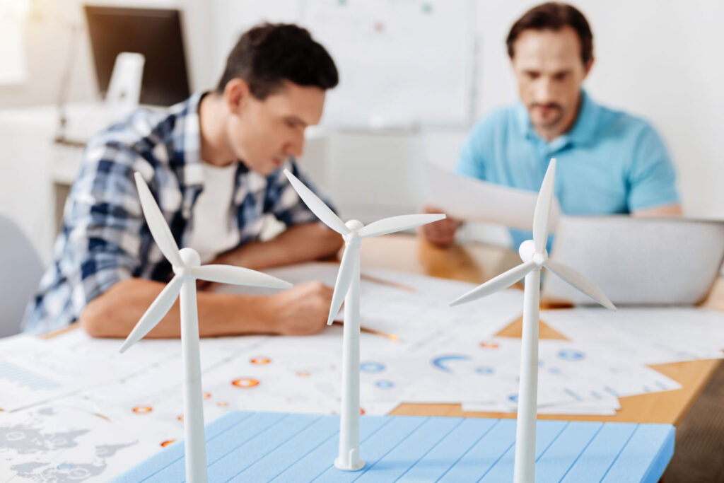 two office workers with model wind turbines in the foreground