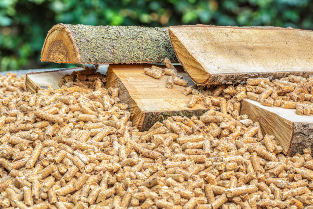 Close up of split wood logs and wood pellets for use as biomass