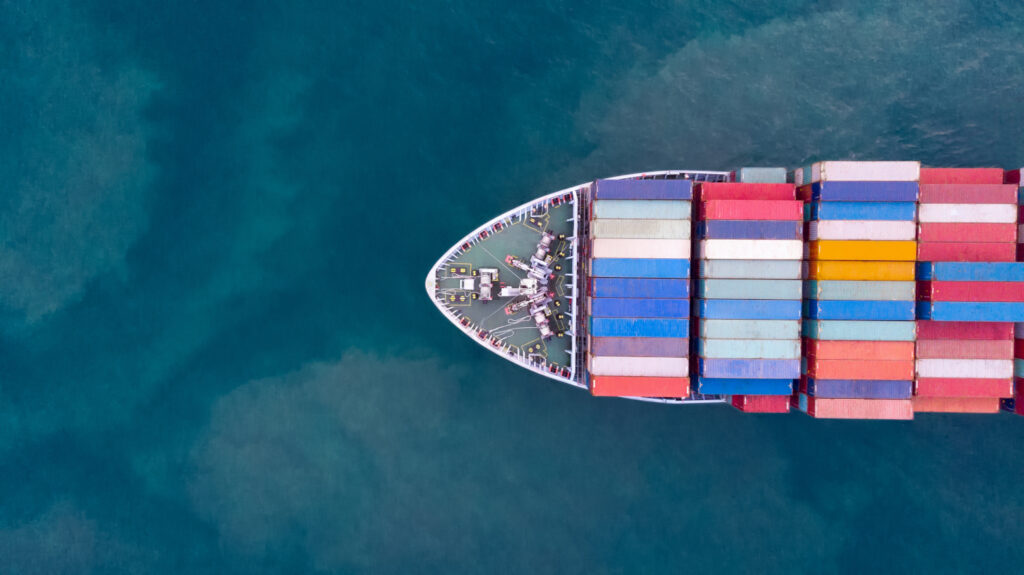 An aerial photo of a cargo ship laden with containers